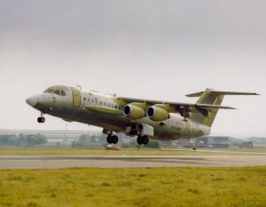 An unpainted research aircraft taking off from a runway on a test flight.