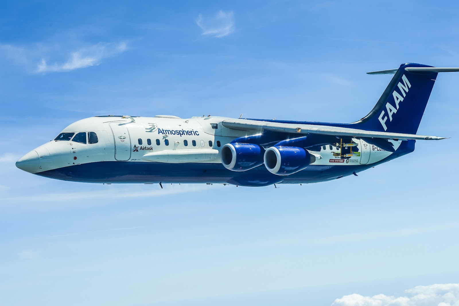 A large blue and white research aircraft flying in clear sky