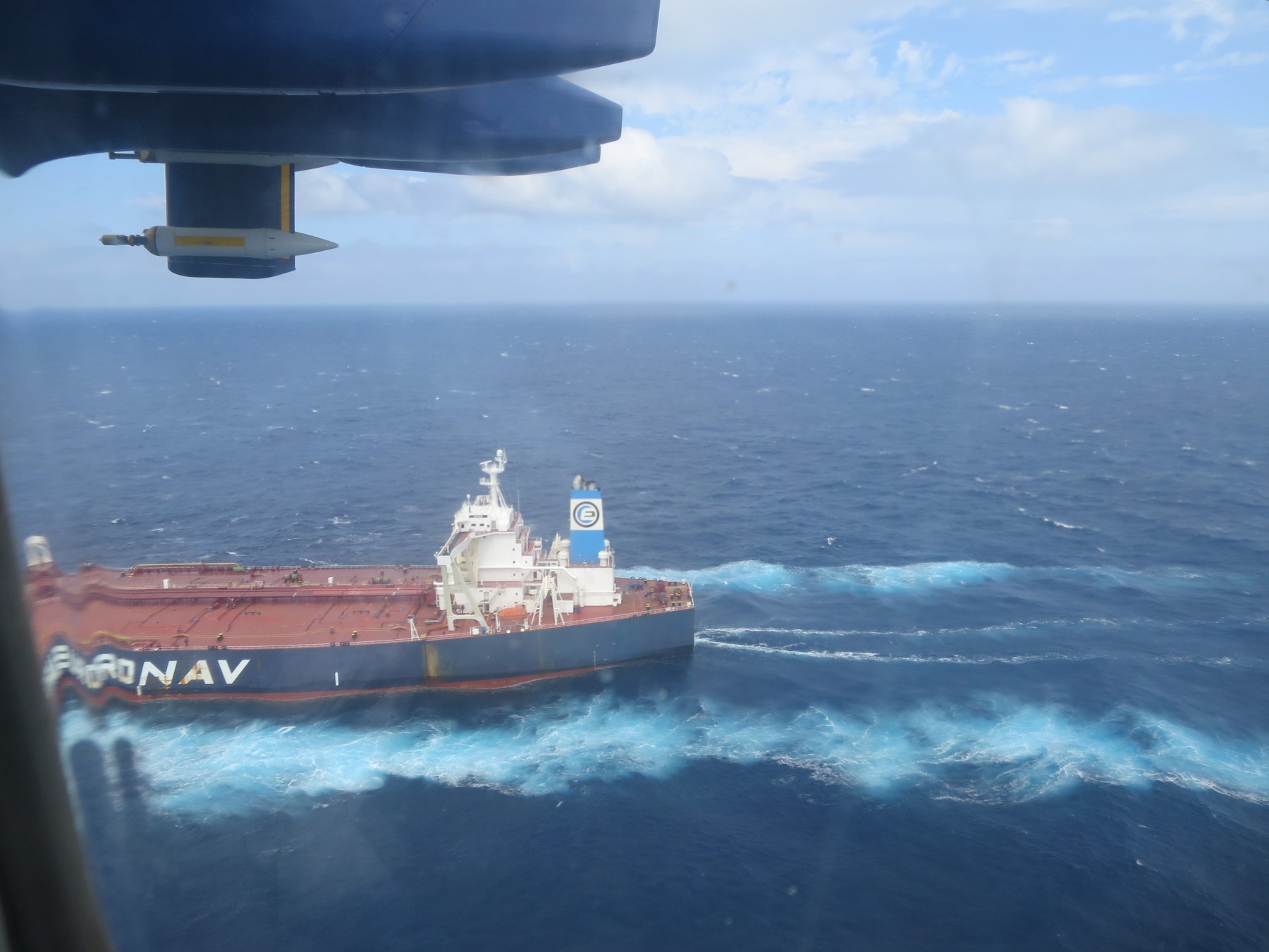 A view of a tanker ship seen from the FAAM aircraft as it flies at low level over the sea.